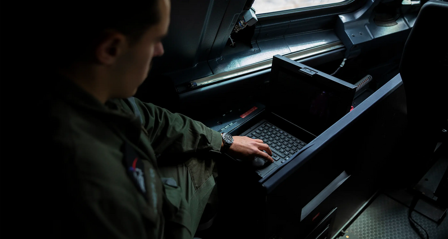 Pilot i cockpit bruger computer, har YEMA Flygraf ur på håndleddet